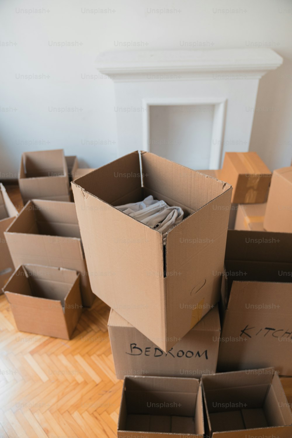 a pile of cardboard boxes sitting on top of a hard wood floor