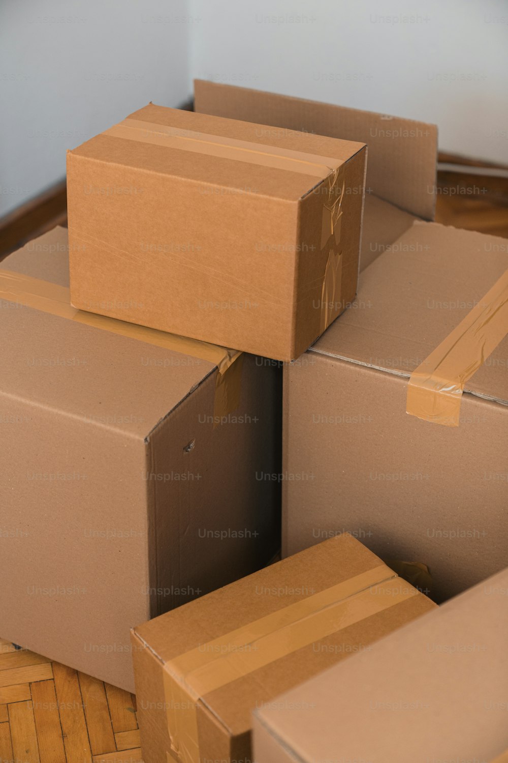 una pila di scatole di cartone sedute sopra un pavimento di legno