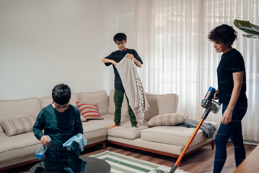 a woman and a boy are cleaning a living room