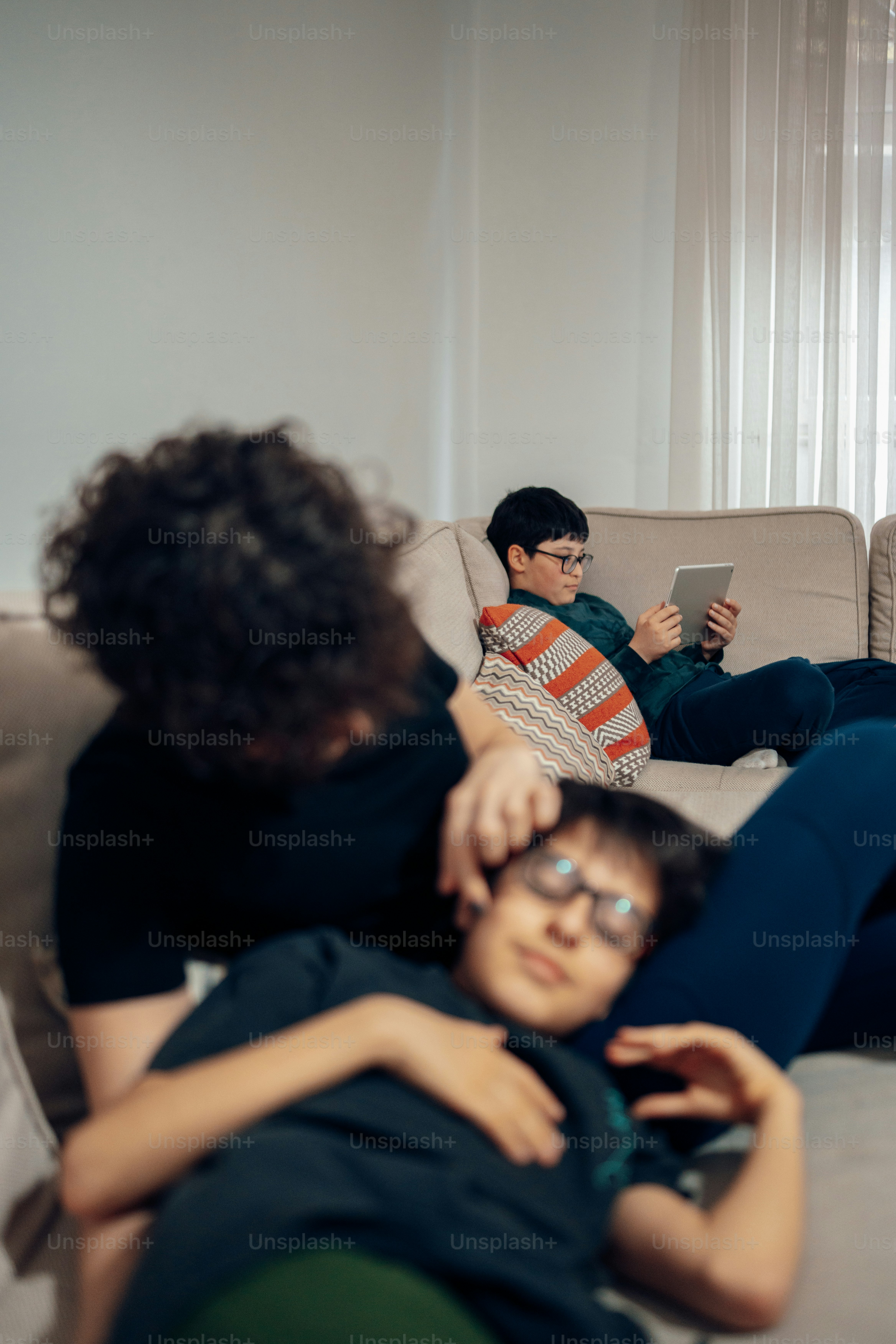 two people sitting on a couch looking at a cell phone