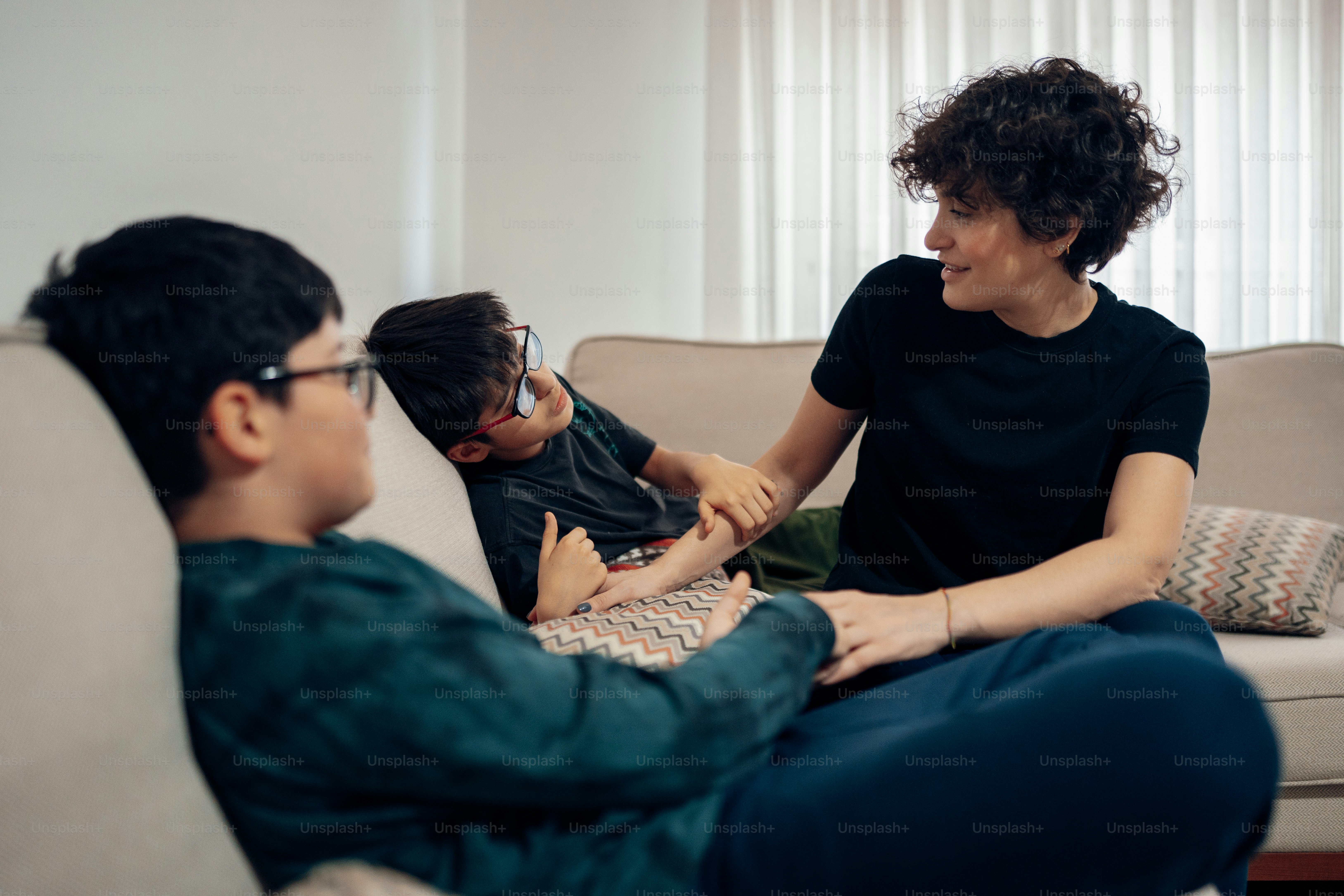 a woman sitting on a couch talking to a child