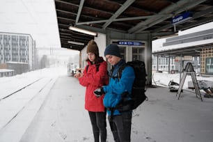 Un par de personas que están de pie en la nieve