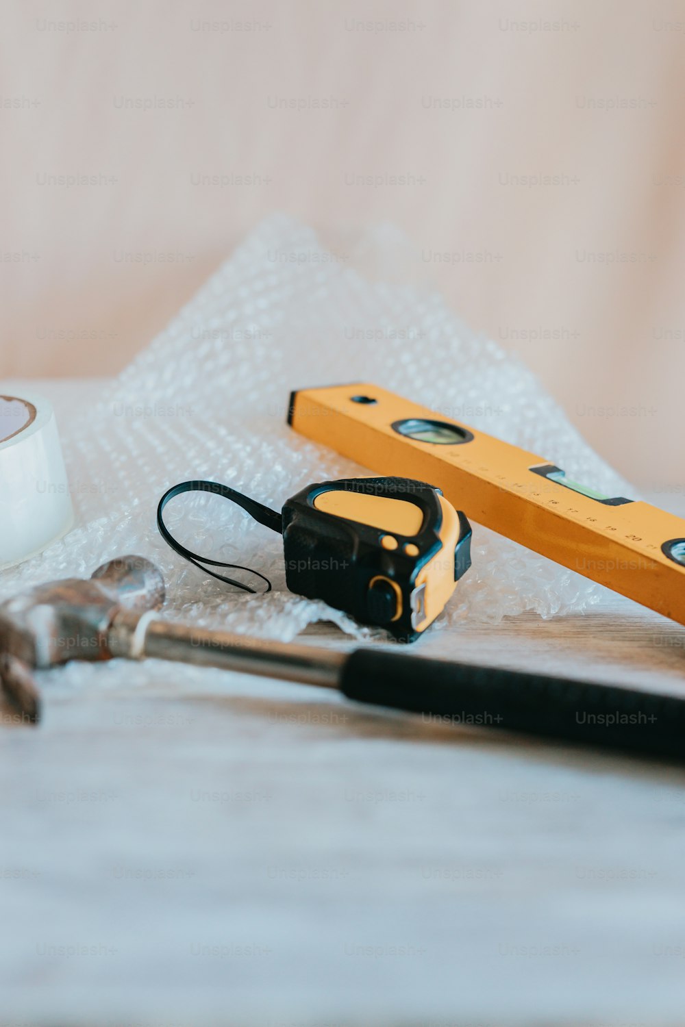 a pair of scissors, a tape measure, and some other tools on a table