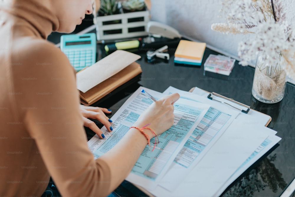 a woman sitting at a desk working on a piece of paper