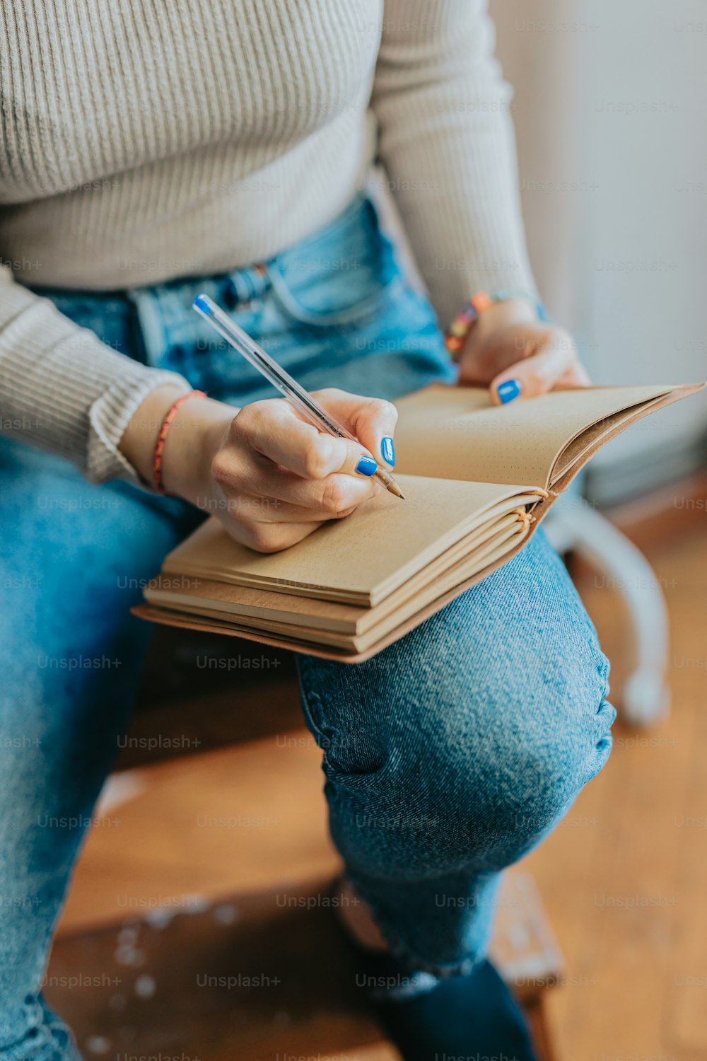 a woman sitting on a chair writing on a notebook