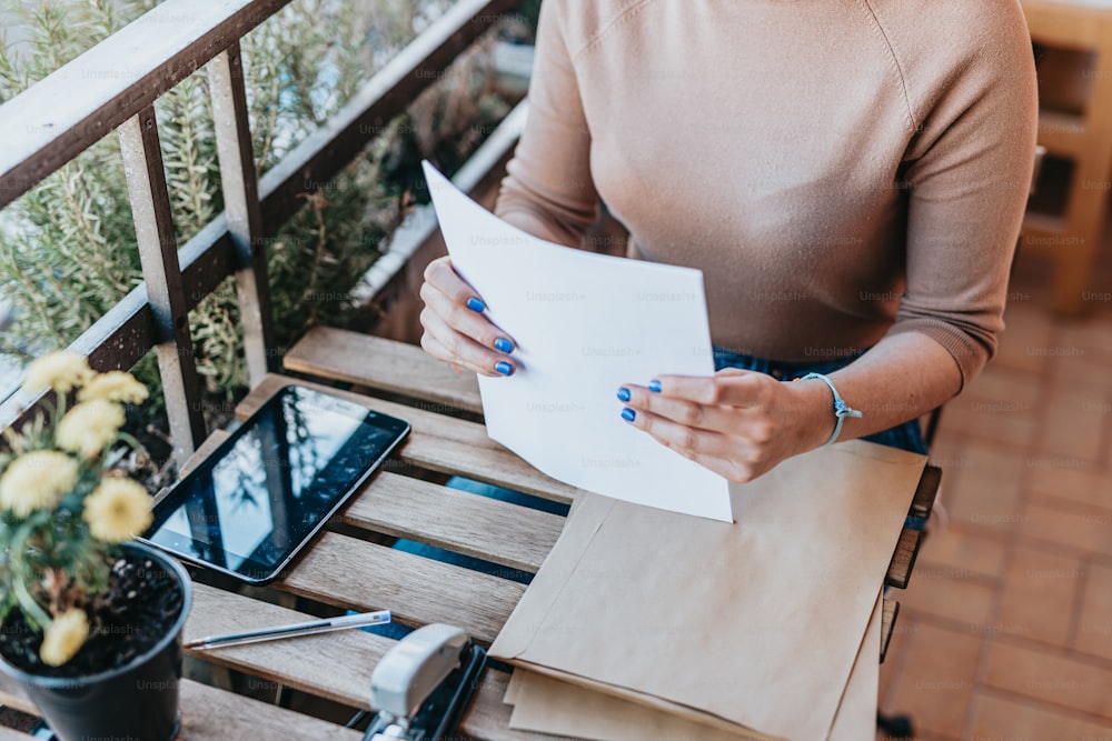 a woman sitting at a table holding a piece of paper