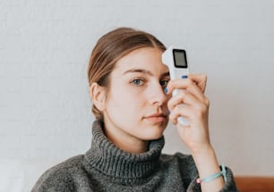 Una mujer sosteniendo un teléfono celular en su cara