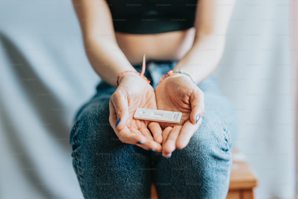 Una mujer sentada en una silla sosteniendo un control remoto