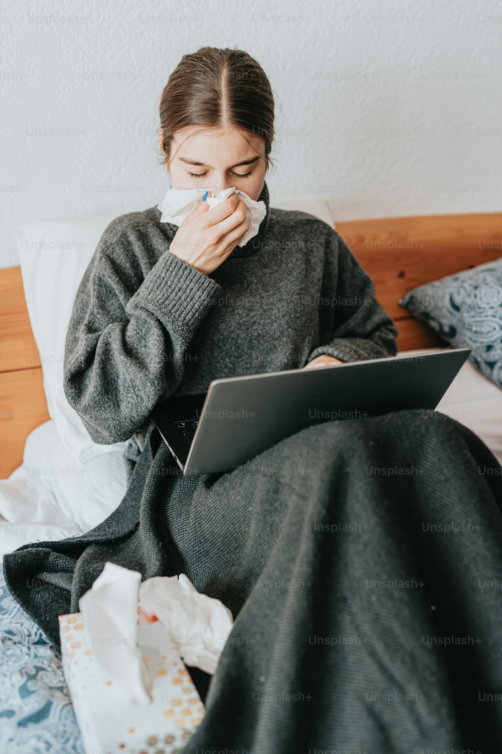 a woman sitting on a bed using a laptop