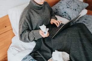 a woman sitting on a bed using a laptop computer