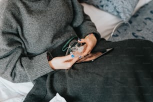 a woman sitting on a bed holding a cell phone