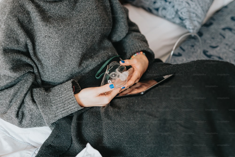 Eine Frau, die auf einem Bett sitzt und ein Handy in der Hand hält