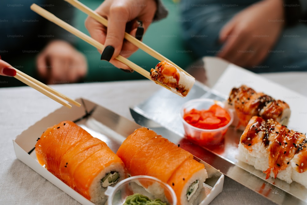 um prato de sushi com pauzinhos saindo dele