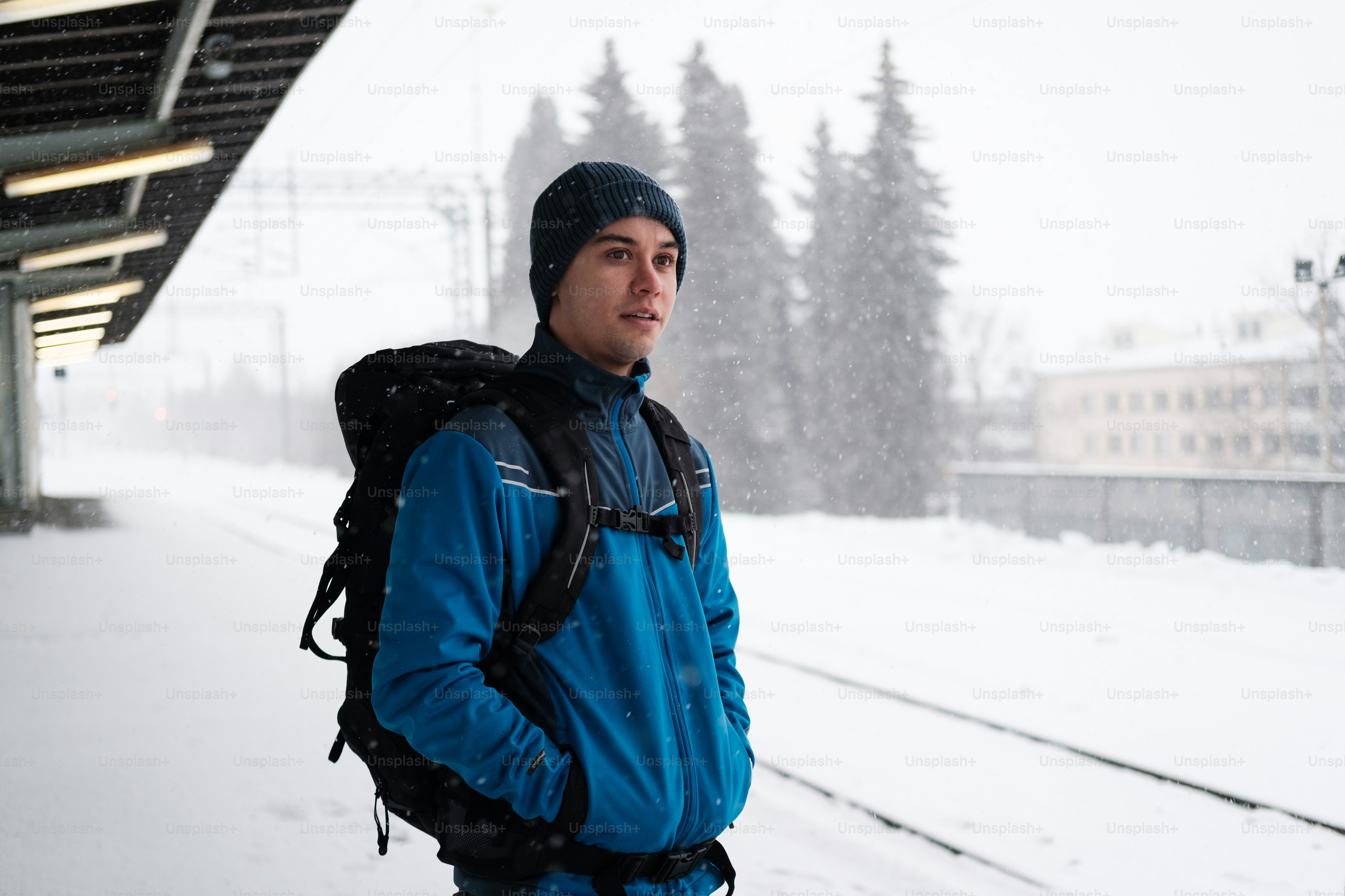Ein Mann mit einem Rucksack steht im Schnee
