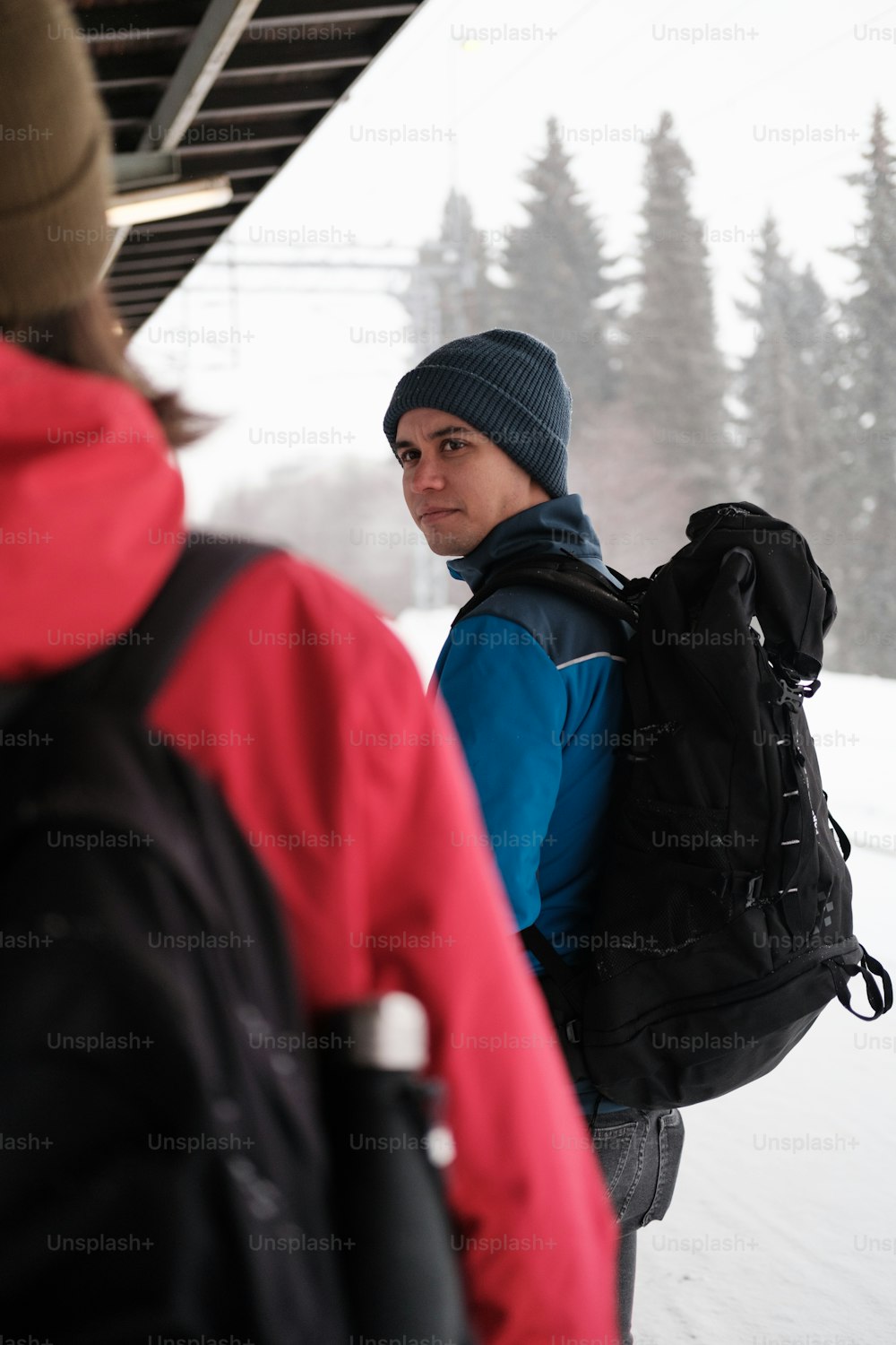 um homem com uma mochila em pé na neve