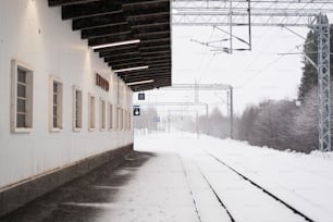 a train station with snow on the ground