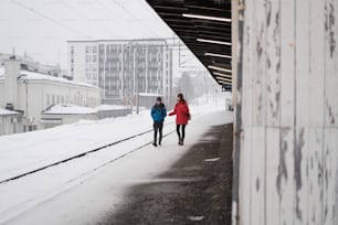 um casal de mulheres andando por uma calçada coberta de neve