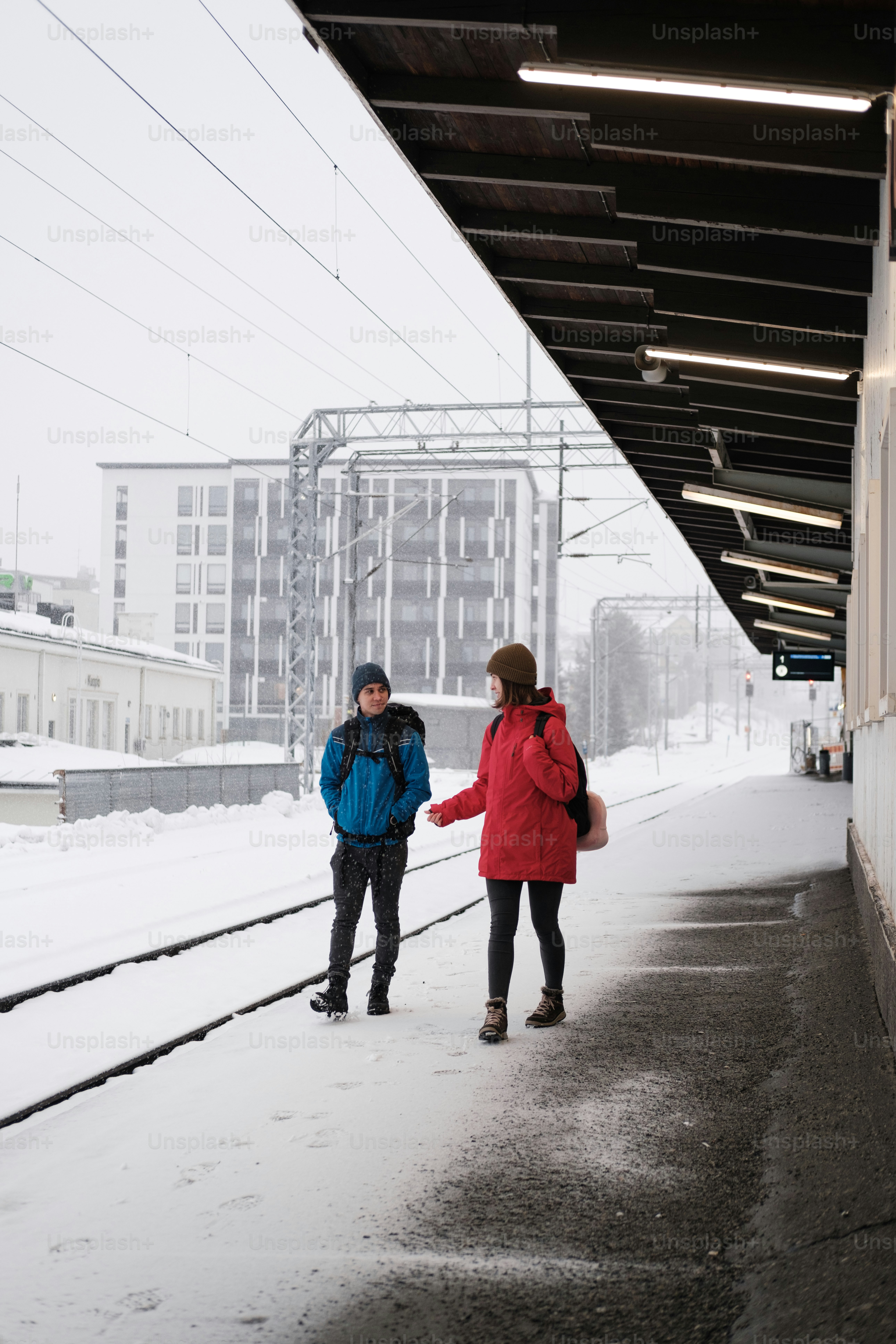 um par de pessoas que estão de pé na neve
