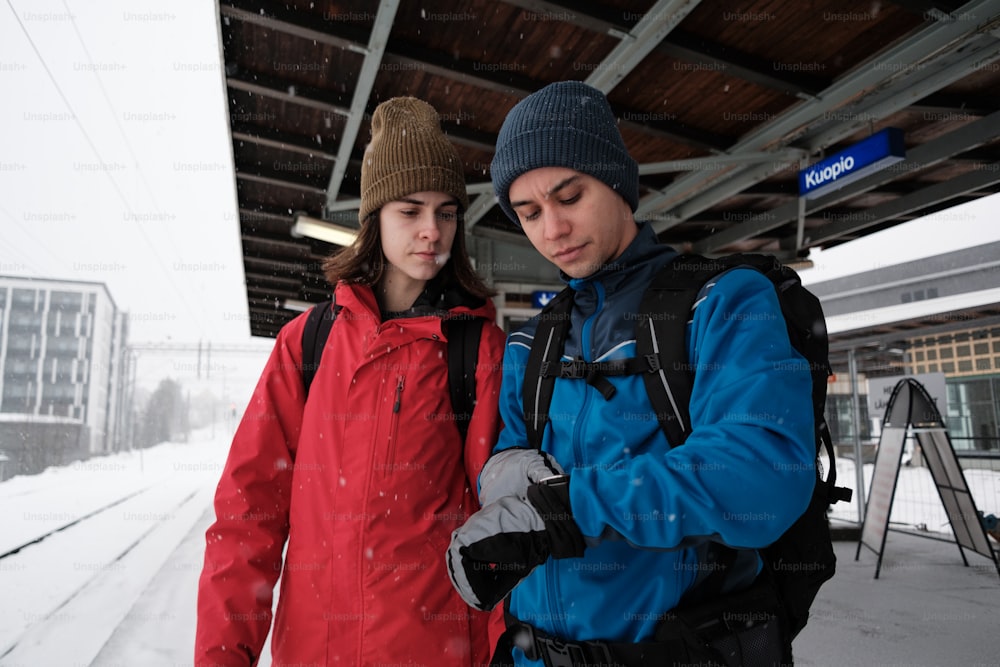 a man and a woman standing next to each other in the snow