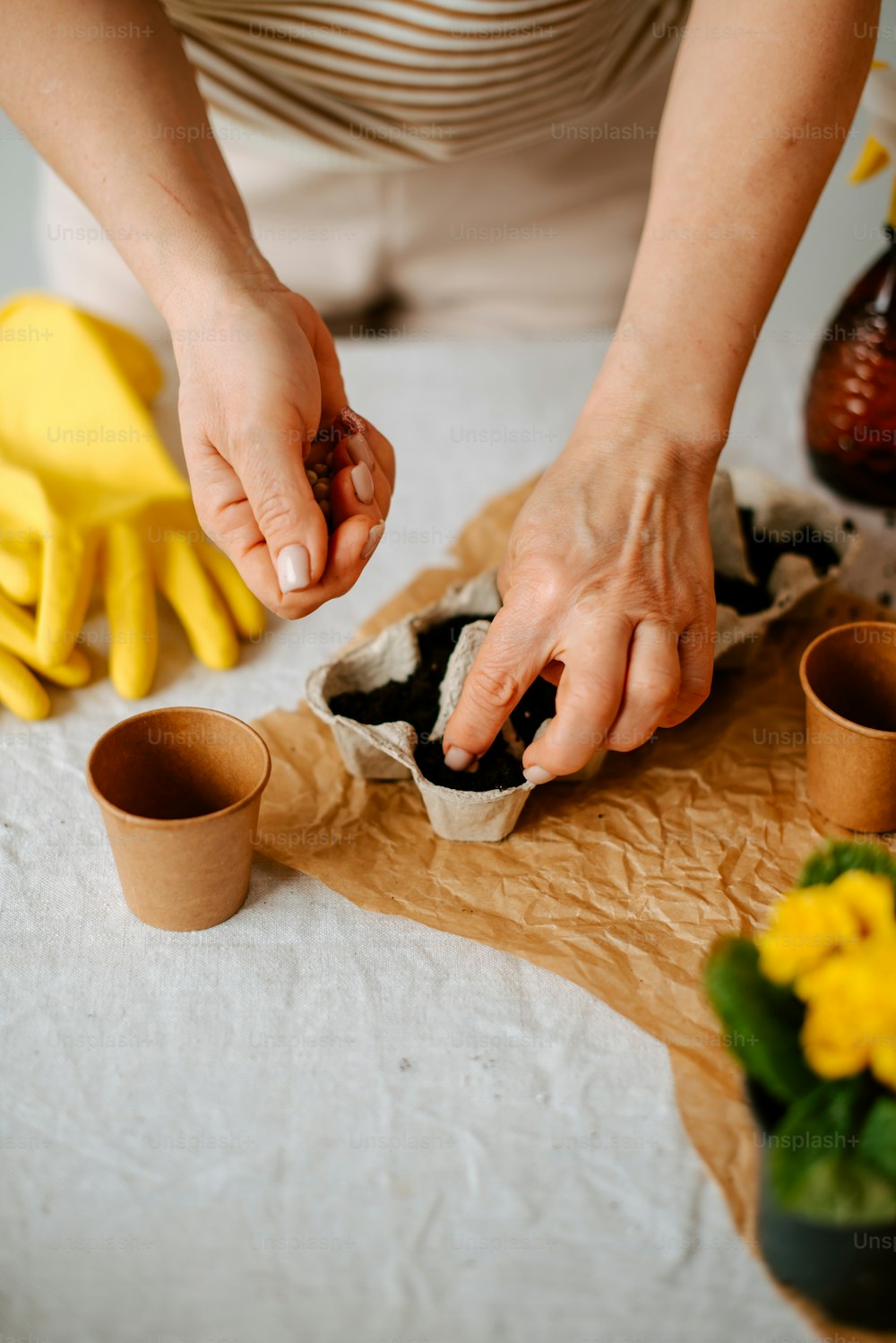 Une femme décore une table avec des fleurs jaunes