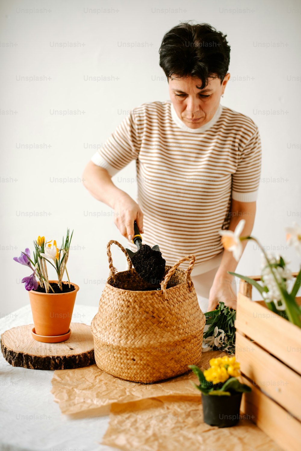 uma mulher está organizando flores em uma cesta