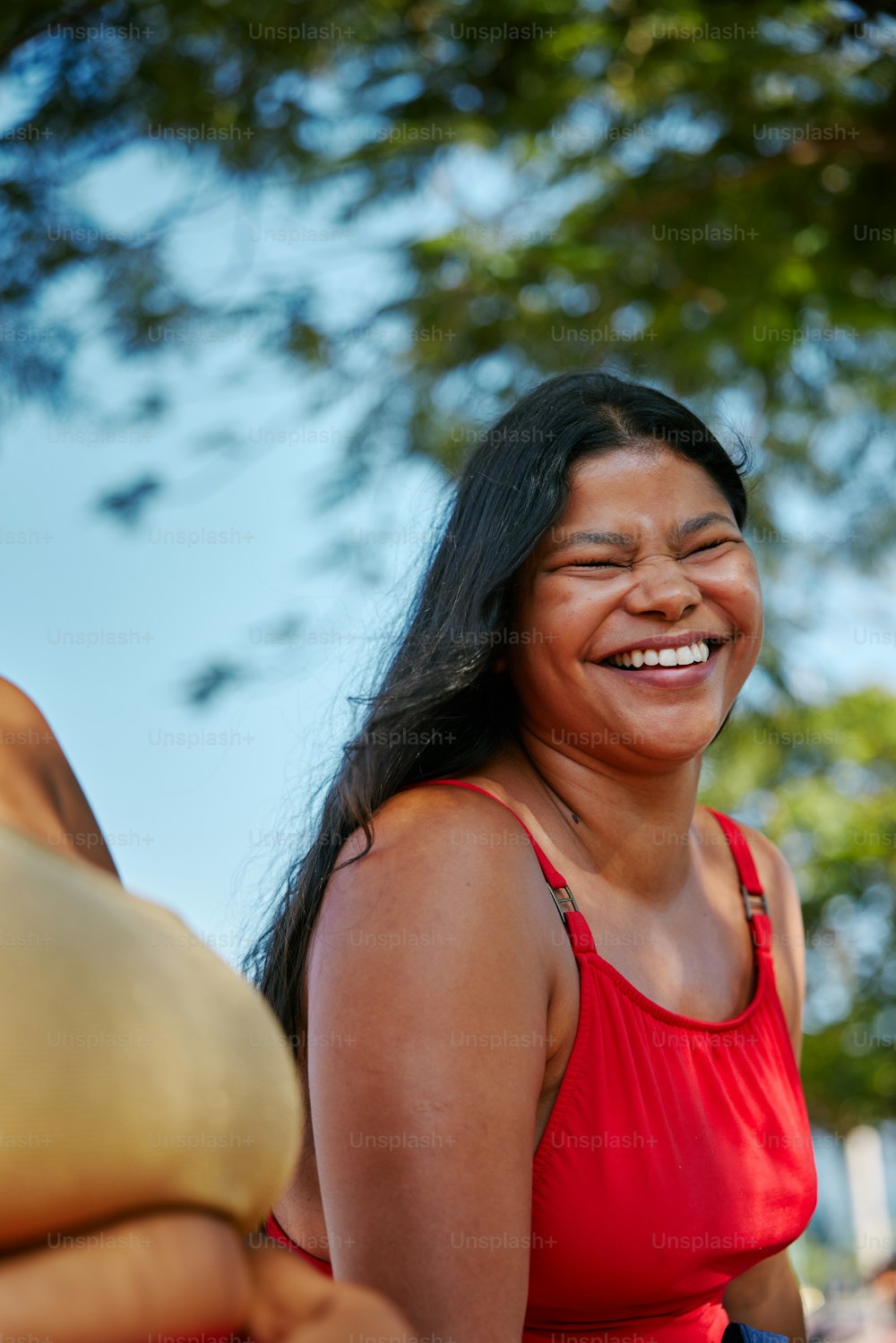 a woman in a red top smiles at the camera