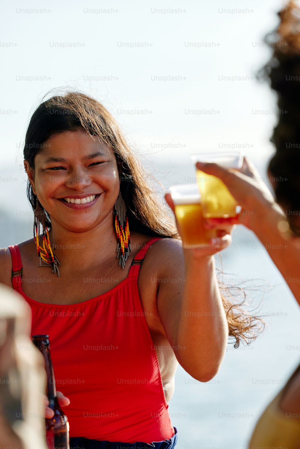 Una mujer sosteniendo un vaso de jugo de naranja