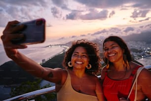 two women taking a picture with a cell phone