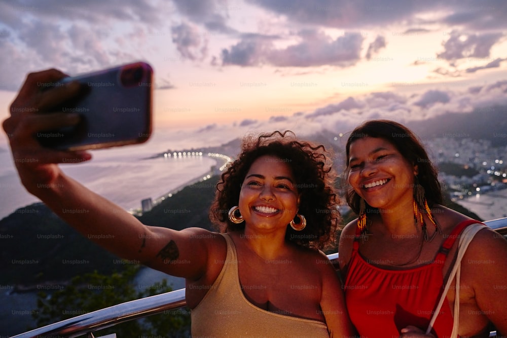 Deux femmes prenant une photo avec un téléphone portable