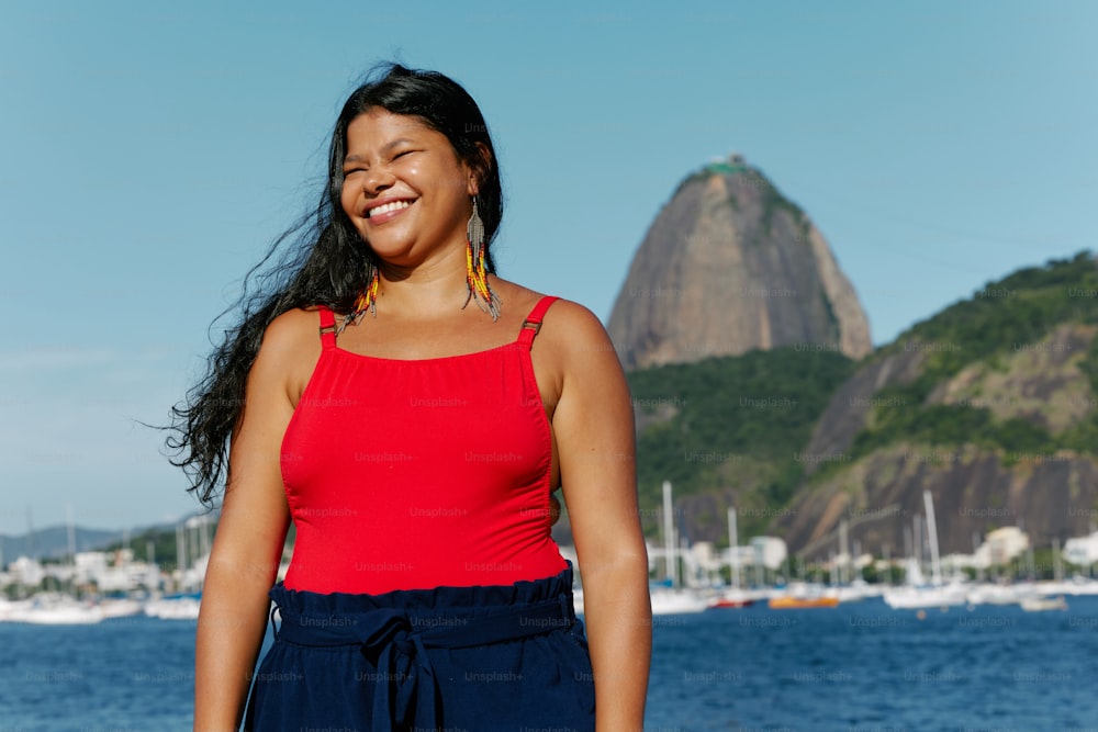 uma mulher em pé na frente de um corpo de água