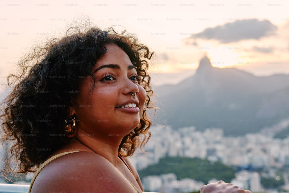 a woman with curly hair sitting on a ledge