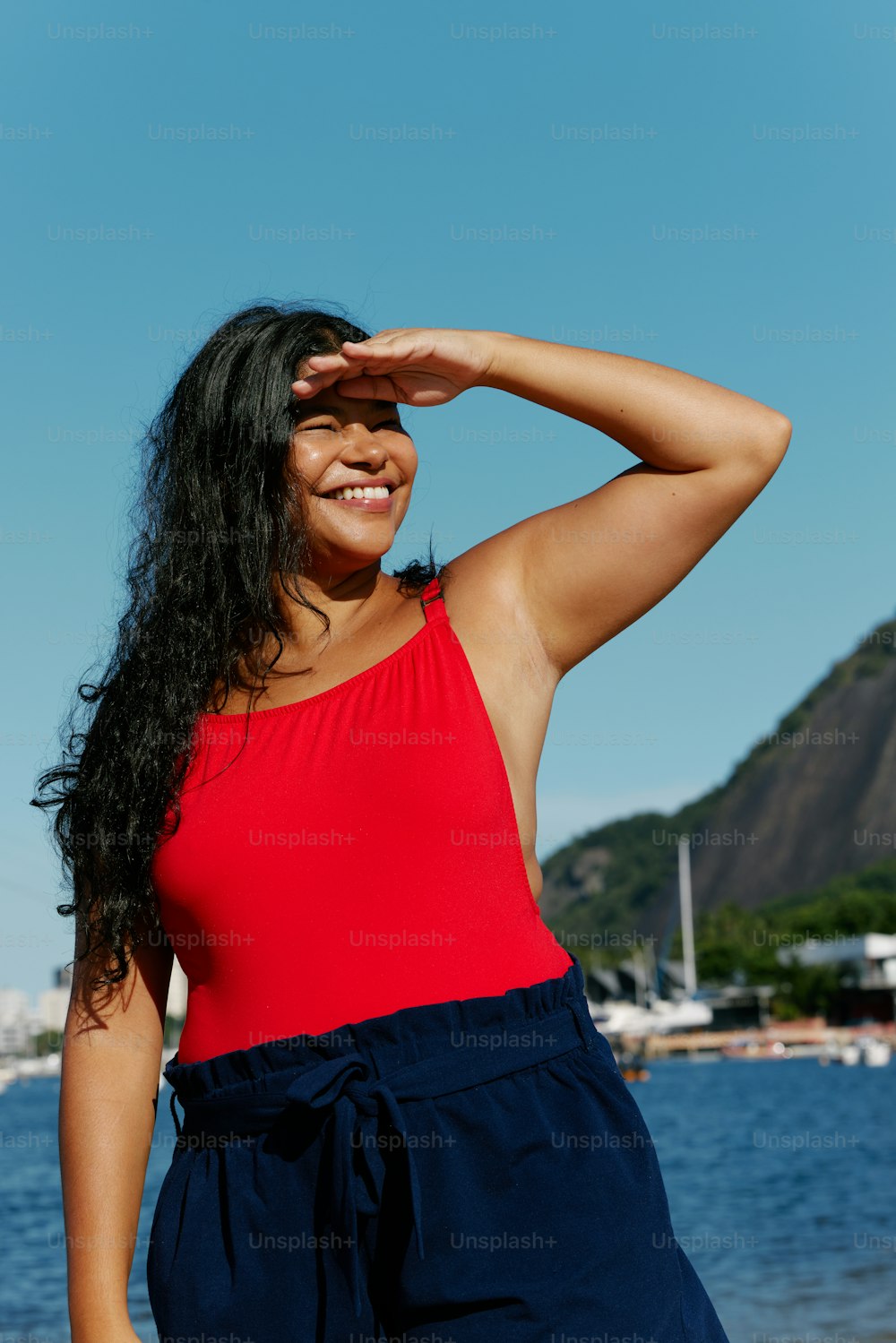 uma mulher em um top vermelho e shorts azuis