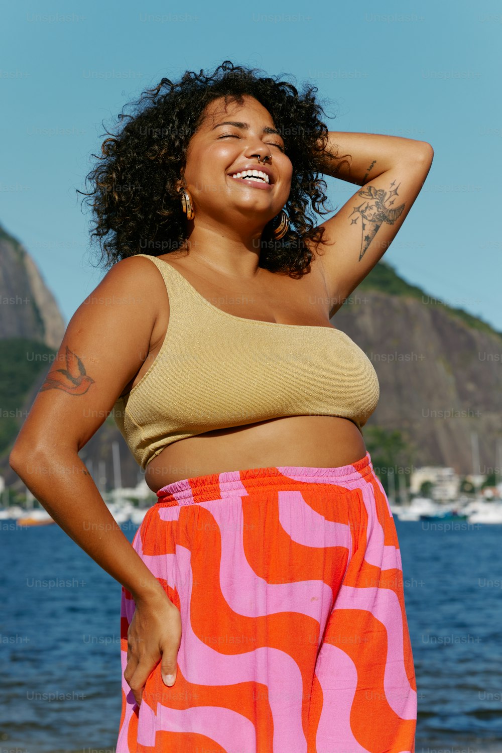 a woman standing on a beach next to a body of water