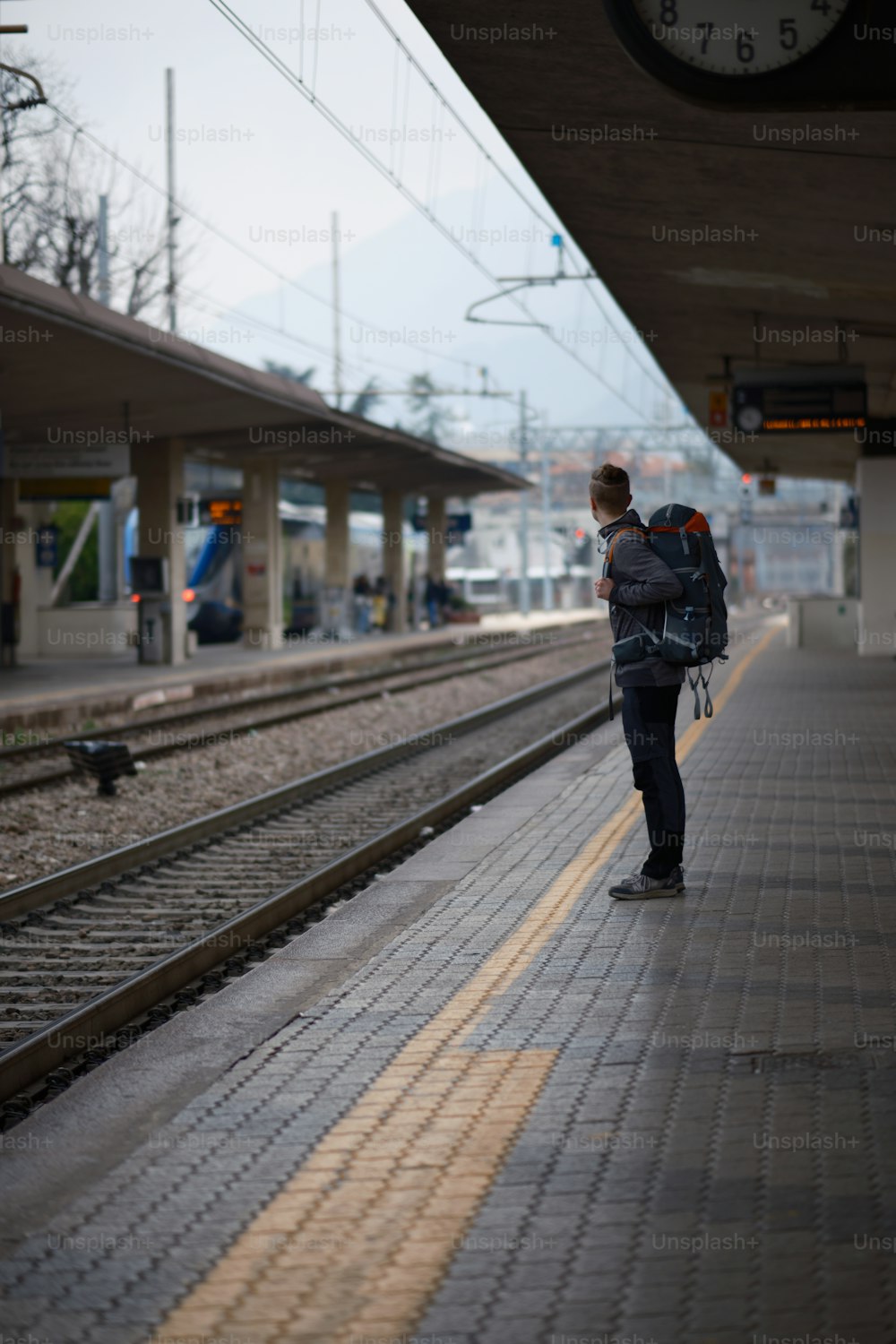 une personne avec un sac à dos attendant un train
