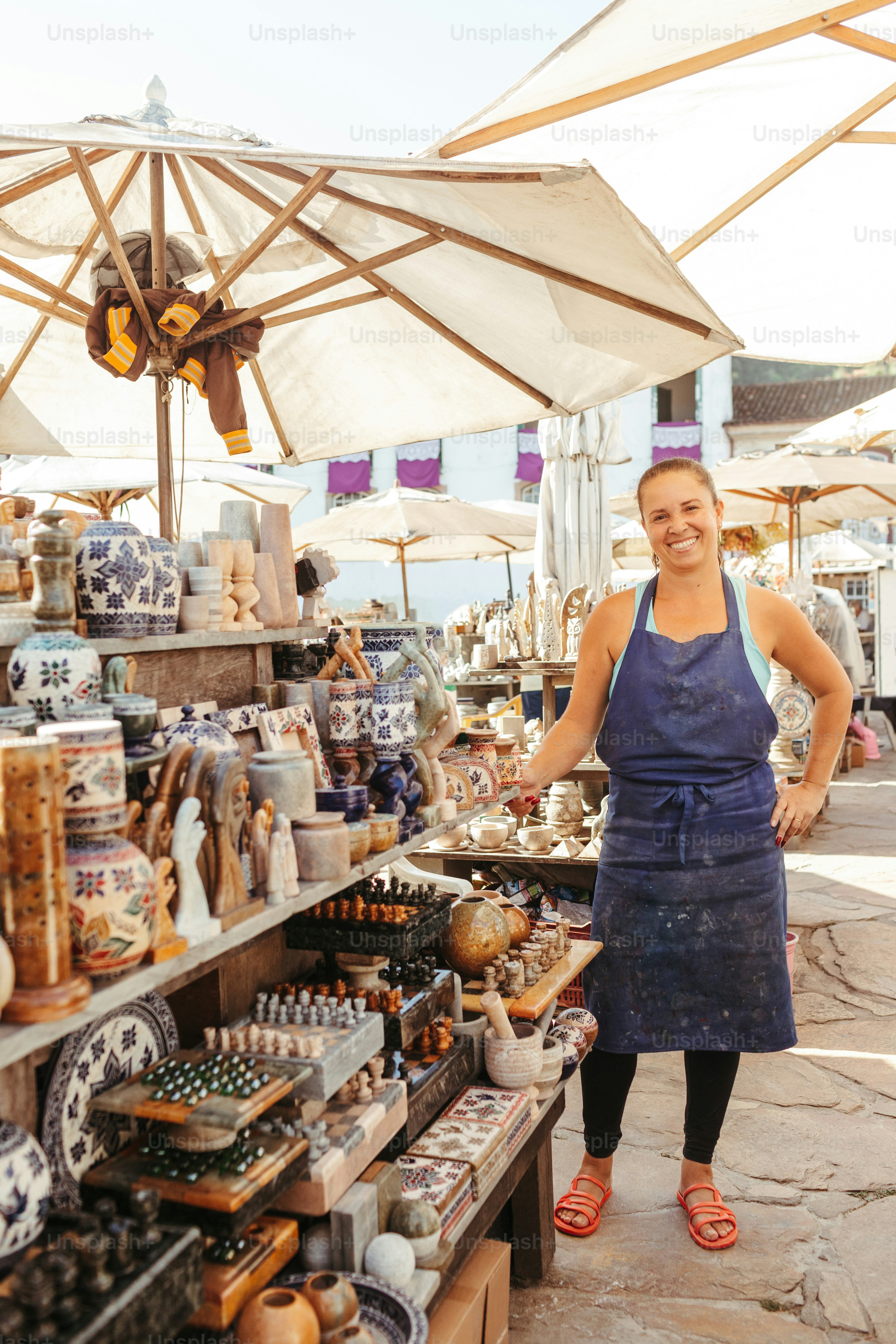 a woman standing in front of a display of pottery