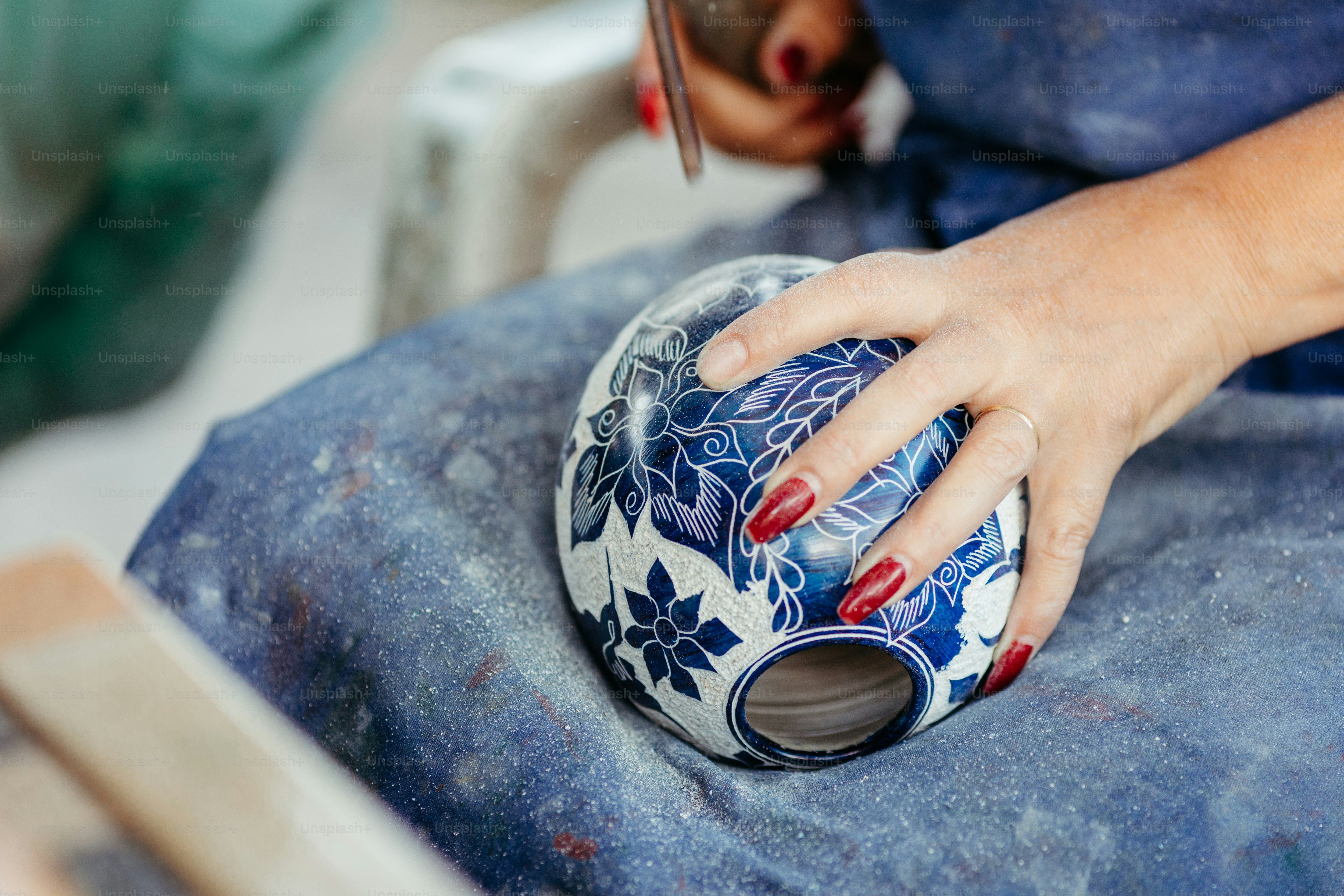 a mão de uma mulher em cima de um vaso azul e branco