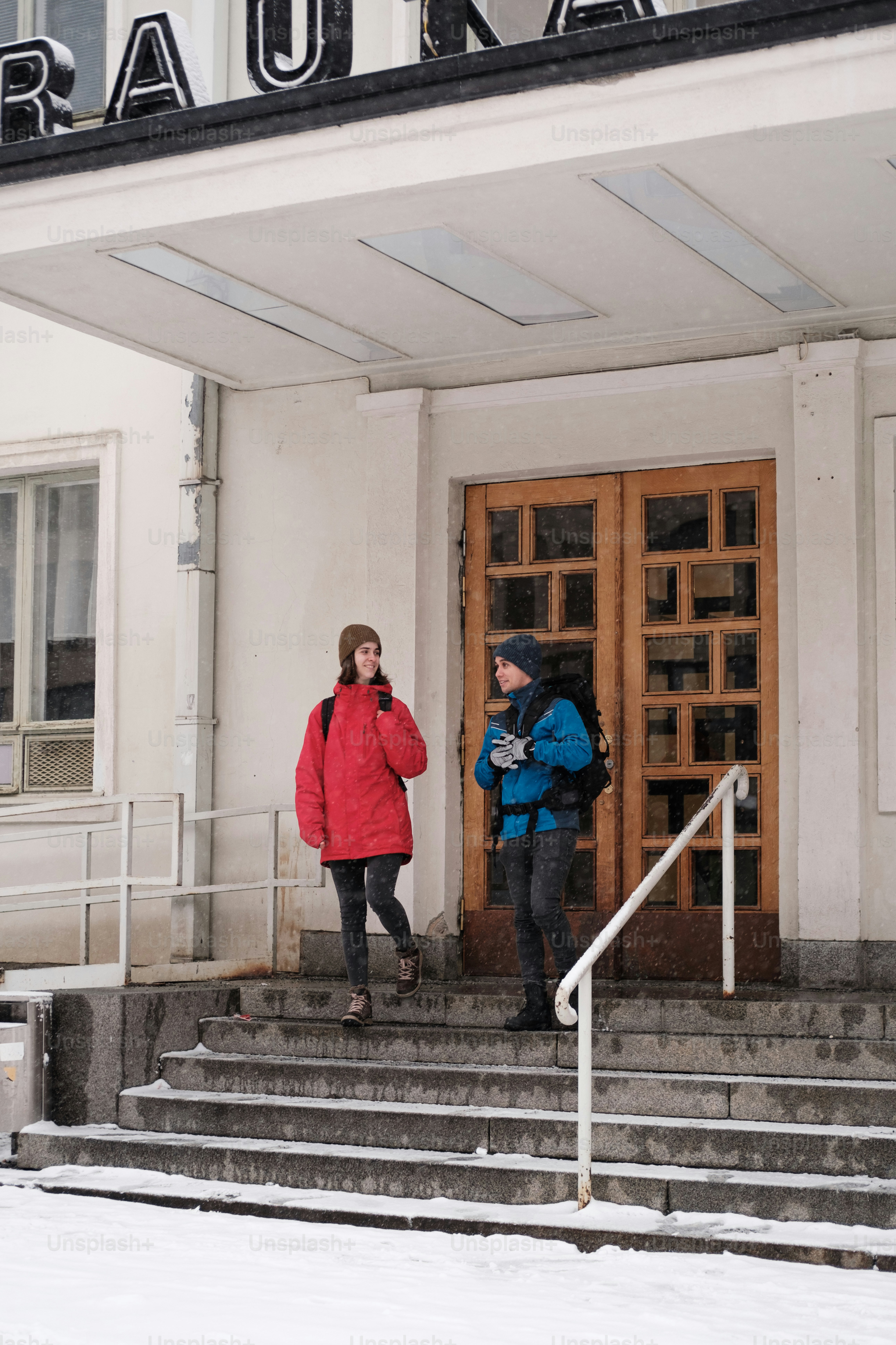 un couple de personnes qui se tiennent devant un immeuble