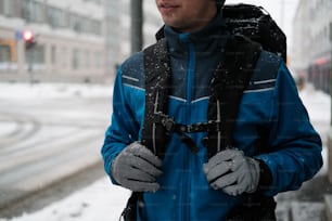 青いジャケットを着た男が雪の中に立っている