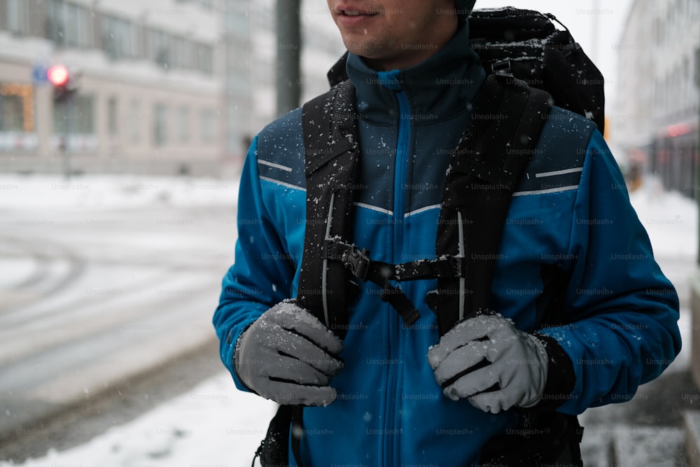 Un hombre con una chaqueta azul está parado en la nieve