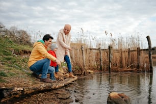 a group of people sitting on a log in the water