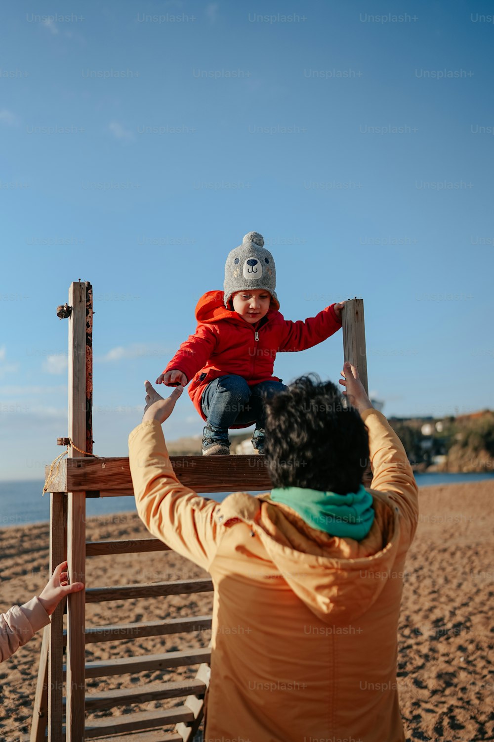 a woman holding a child on top of a wooden structure