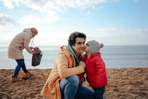 a man and a child on a beach with a teddy bear