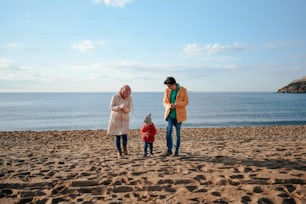 Zwei Frauen und ein Kind stehen am Strand