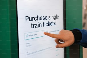 a hand pointing at a sign that says purchase single train tickets