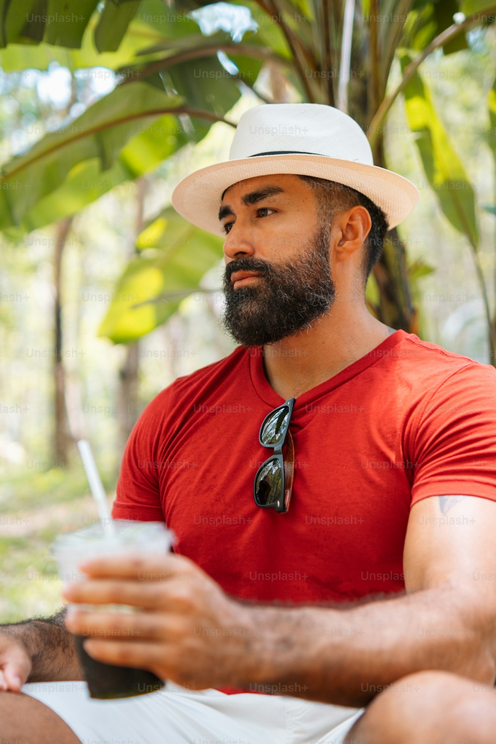 a man with a beard wearing a red shirt and a white hat