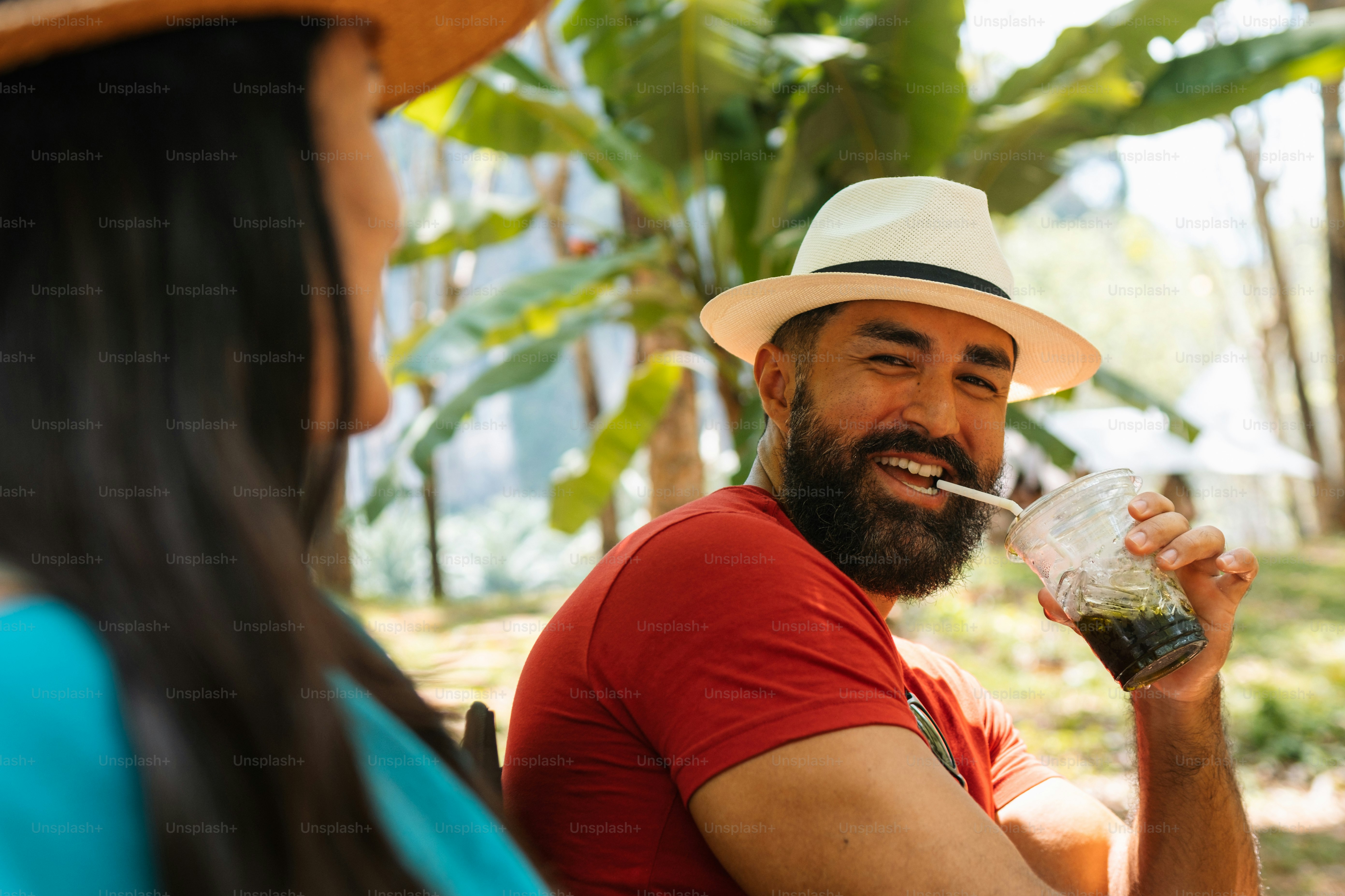 Un hombre con un sombrero de paja bebiendo de un vaso