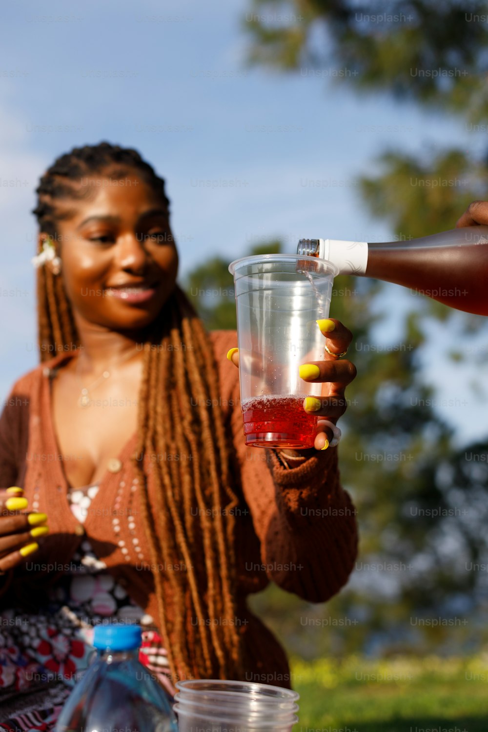 a woman holding a glass with a liquid in it