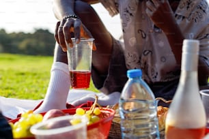 a woman sitting on the grass with a bottle of wine