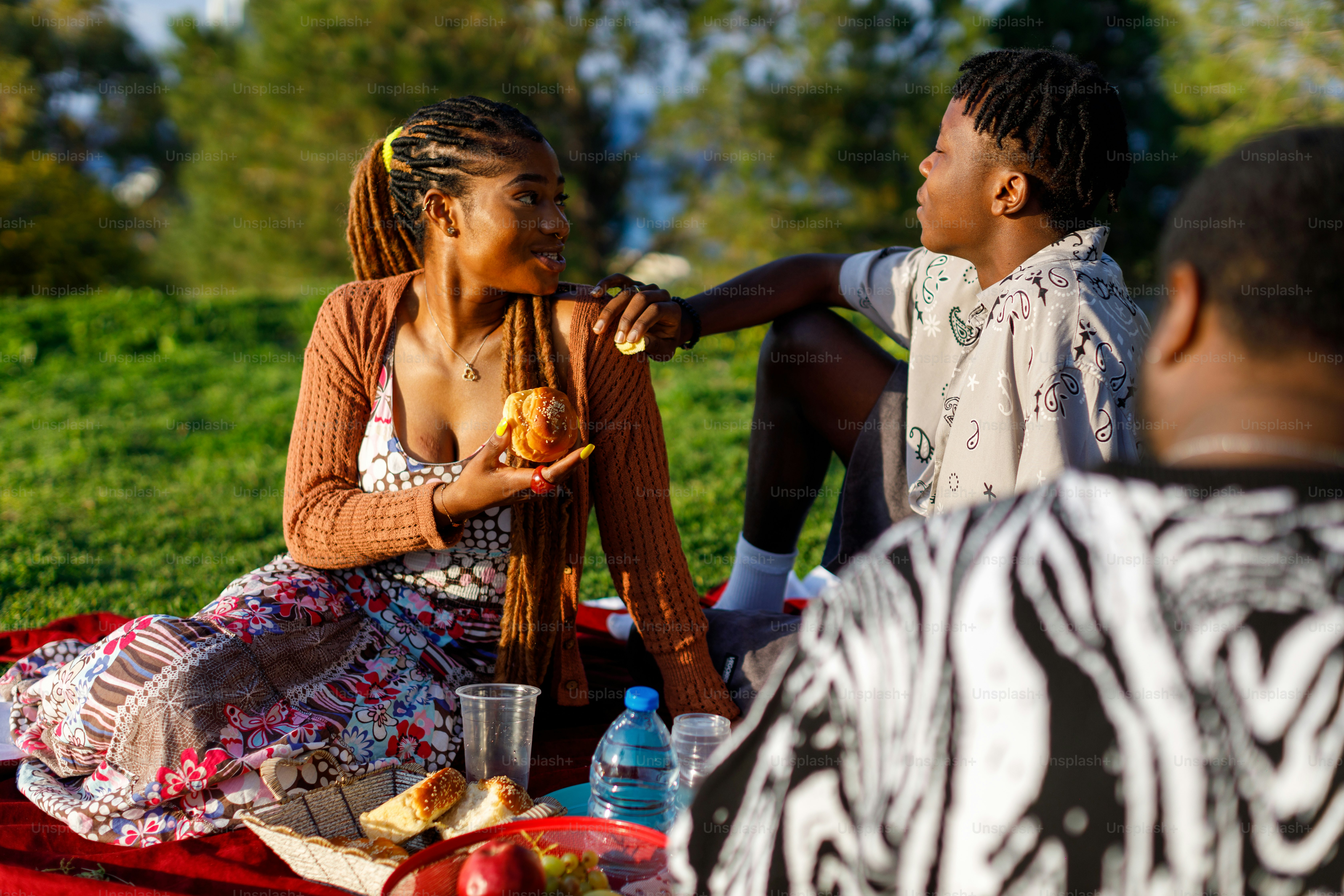 A man and a woman sitting on a blanket eating food photo Food Image