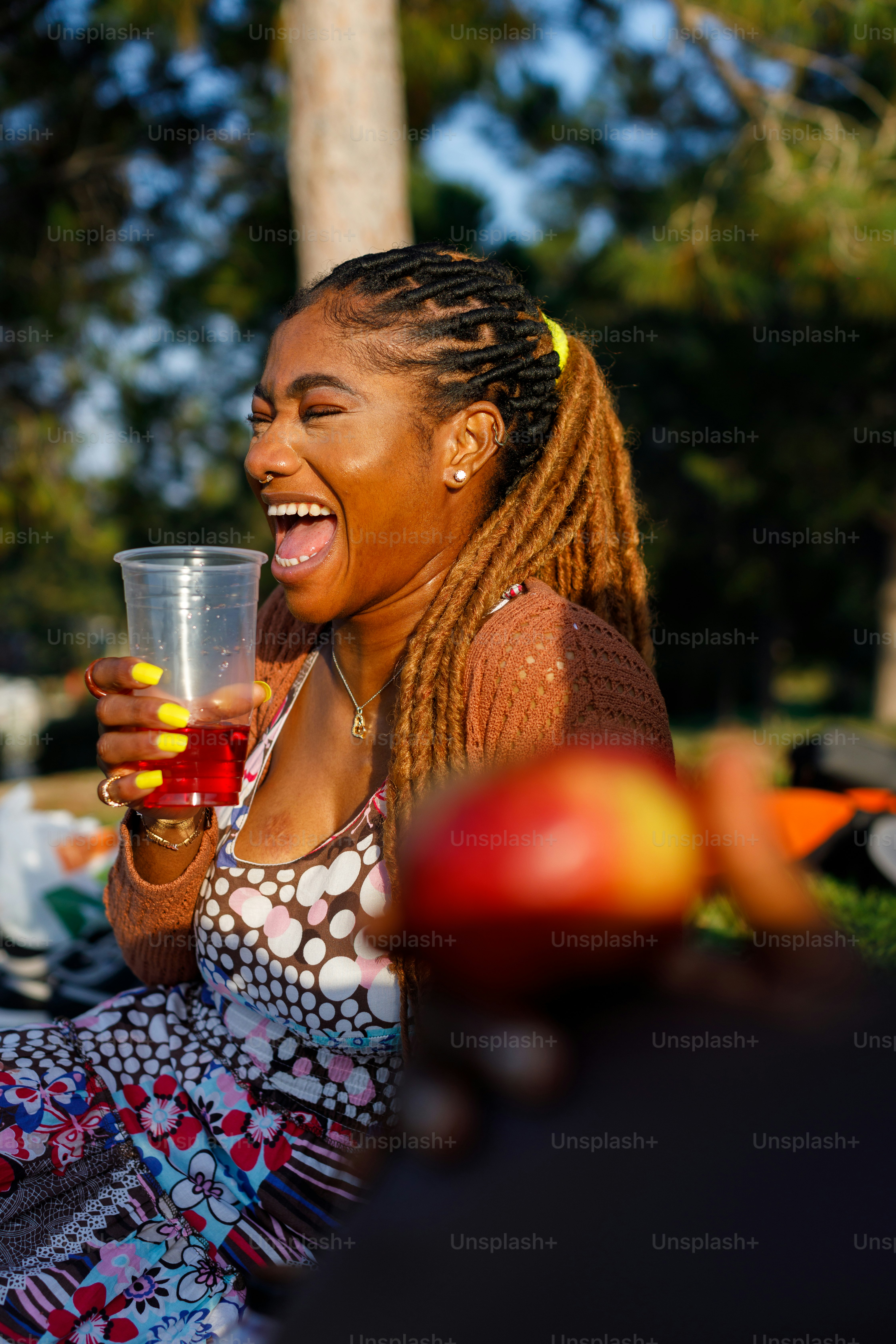 a woman sitting on the ground holding a glass of wine